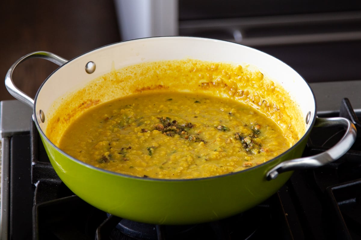red lentil dal in a skillet, after cooking and topping with thecha