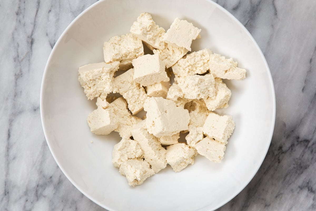 torn tofu chunks in a white bowl 