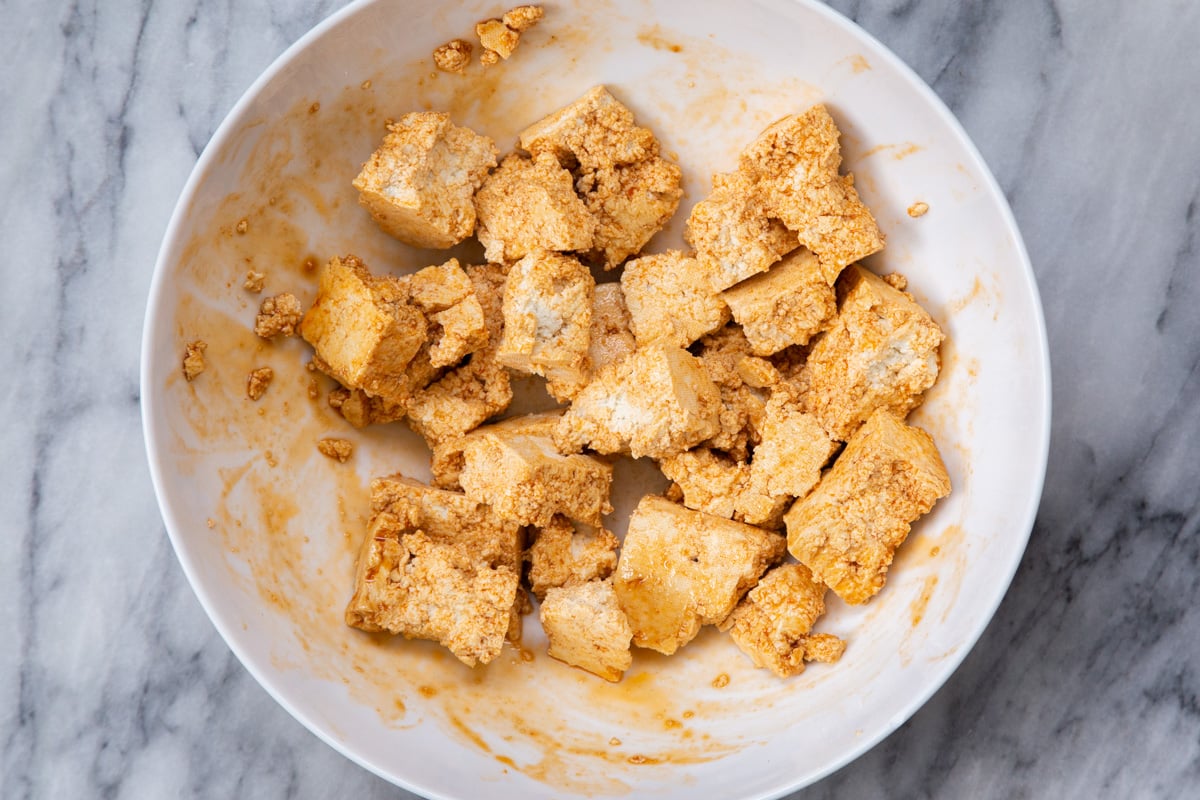 marinated tofu chunks in a white bowl 