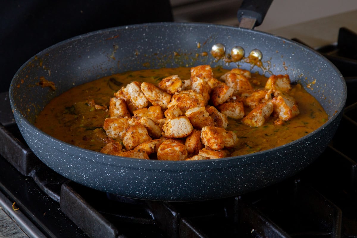 adding tofu back to the pan of sauce
