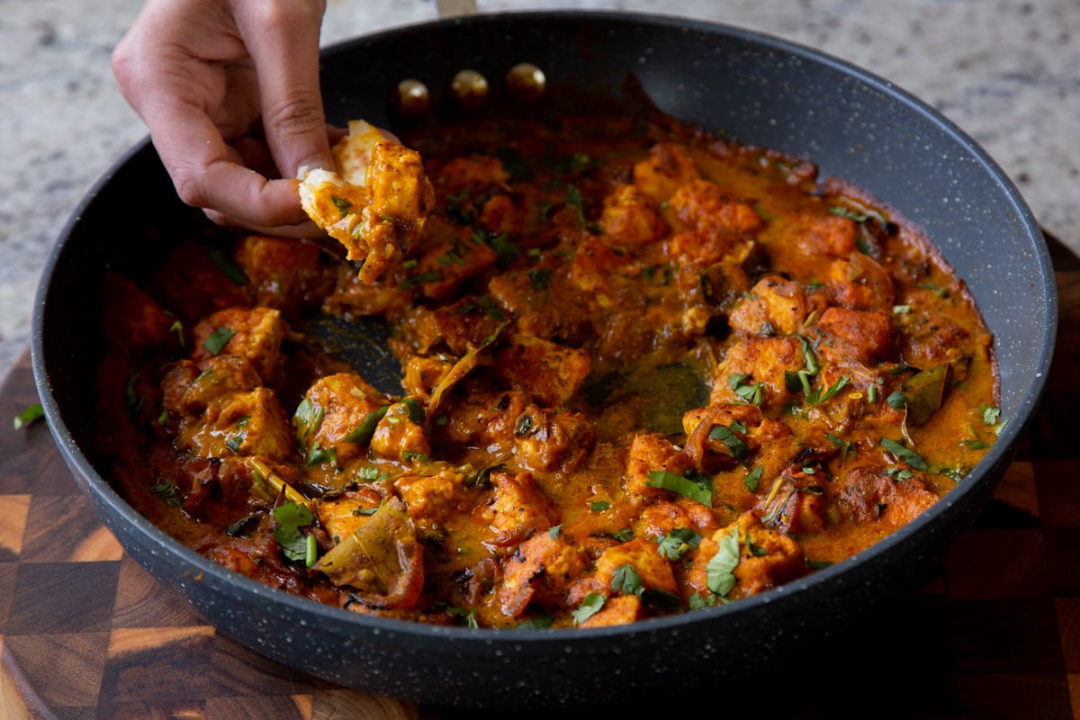 dipping flatbread into tofu pepper fry in the skillet