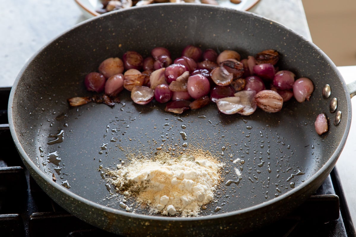 onion in the frying pan after cooking, with the flour and herbs added
