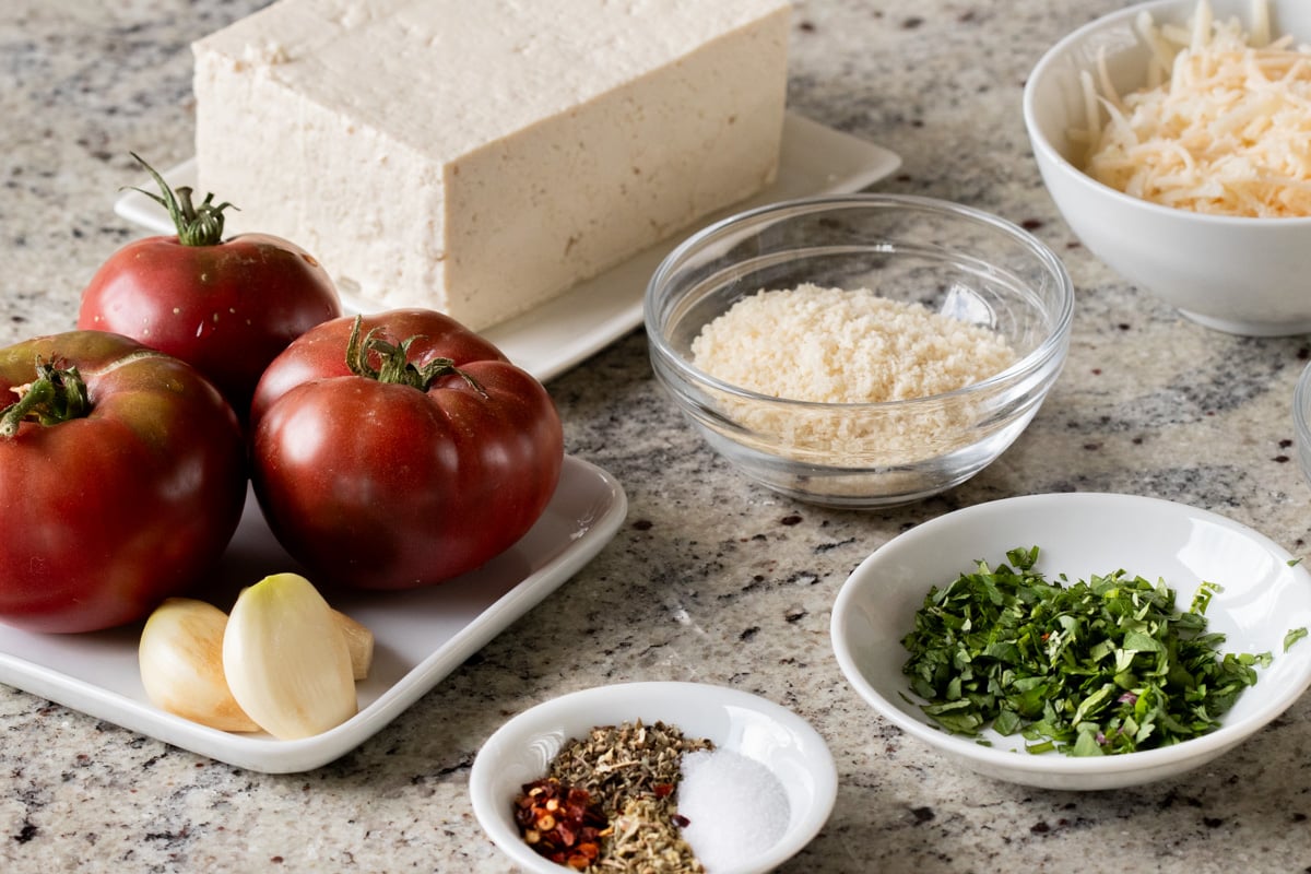 tomatoes, tofu, and other caprese ingredients on a kitchen counter