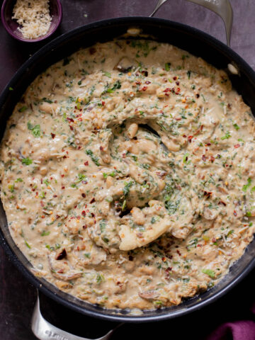 panful of Tuscan beans with a piece of flatbread dipped into it