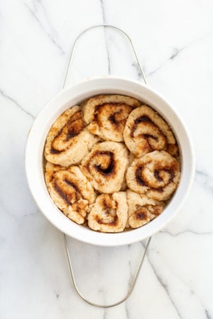 Our Vegan Gluten free Cinnamon rolls in a stoneware dish on marble